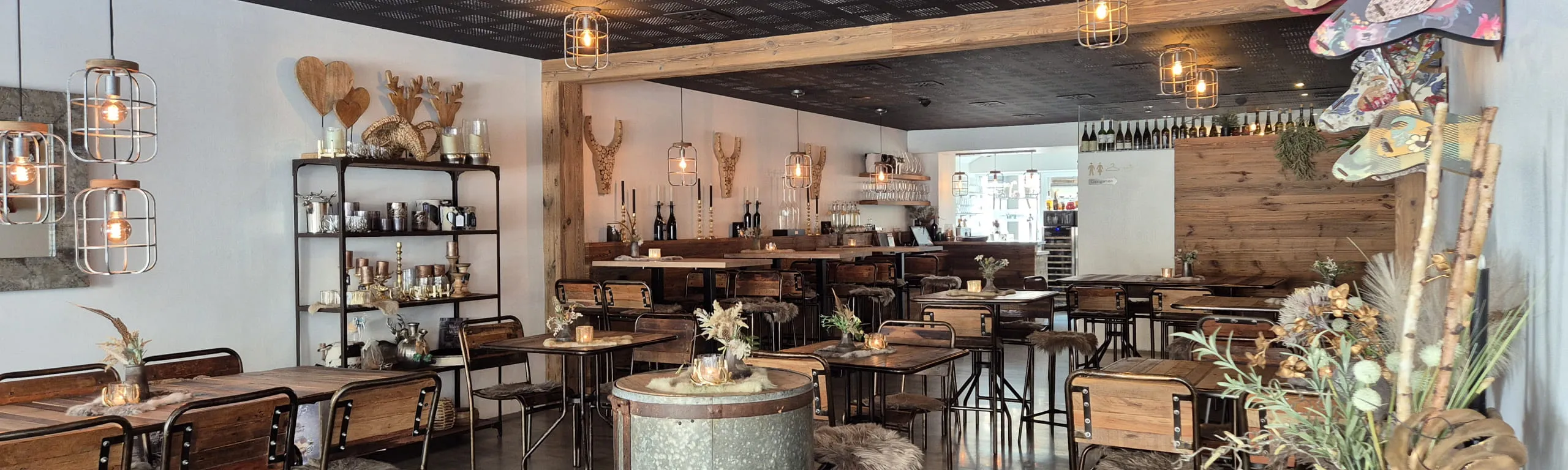 Innenansicht eines Restaurants mit Holzstühlen und Tischen sowie dekorativen Elementen.
