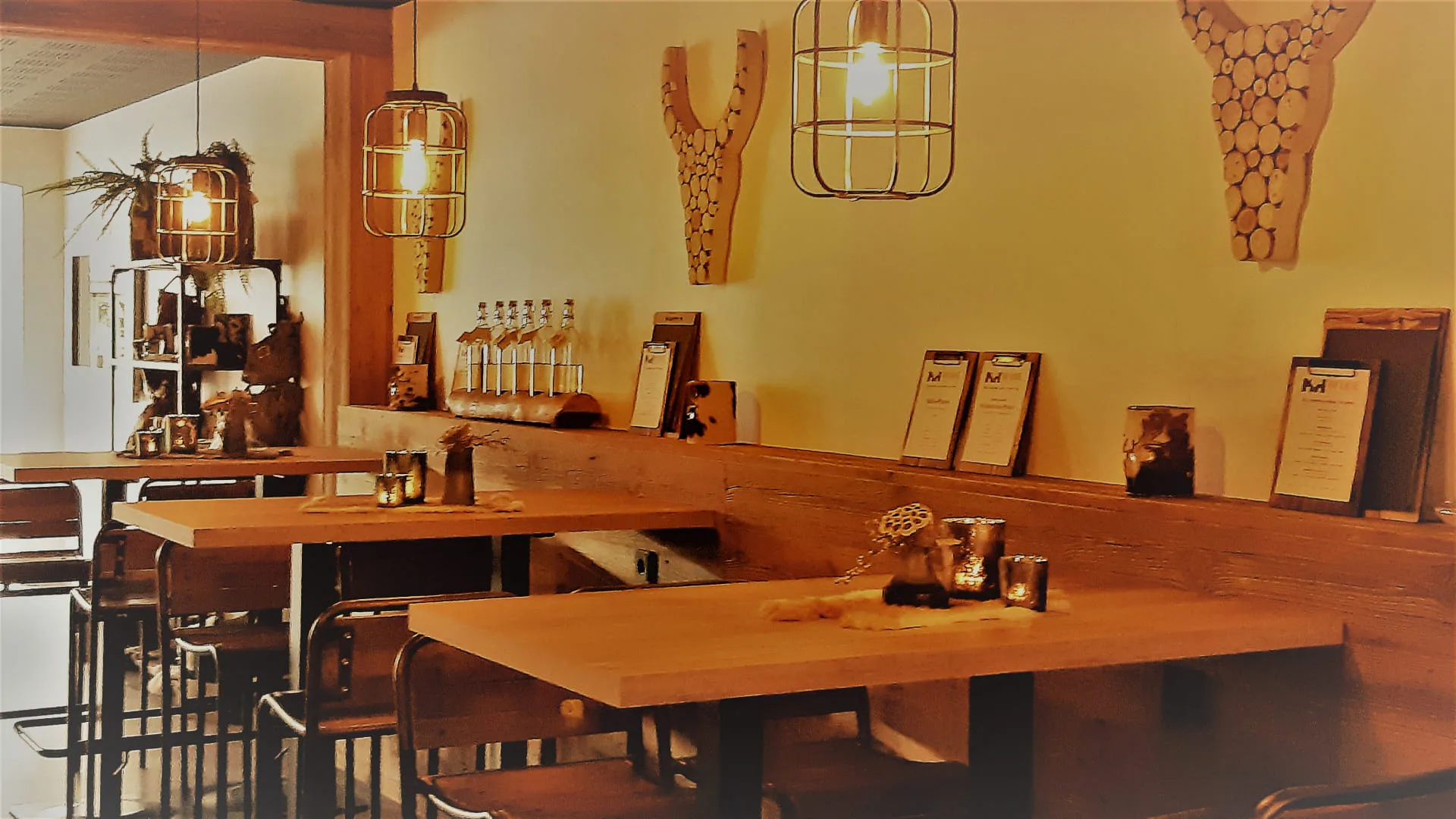 Gemütliches Restaurant mit Holztischen, Wanddekoration und flackernden Lichtern.
