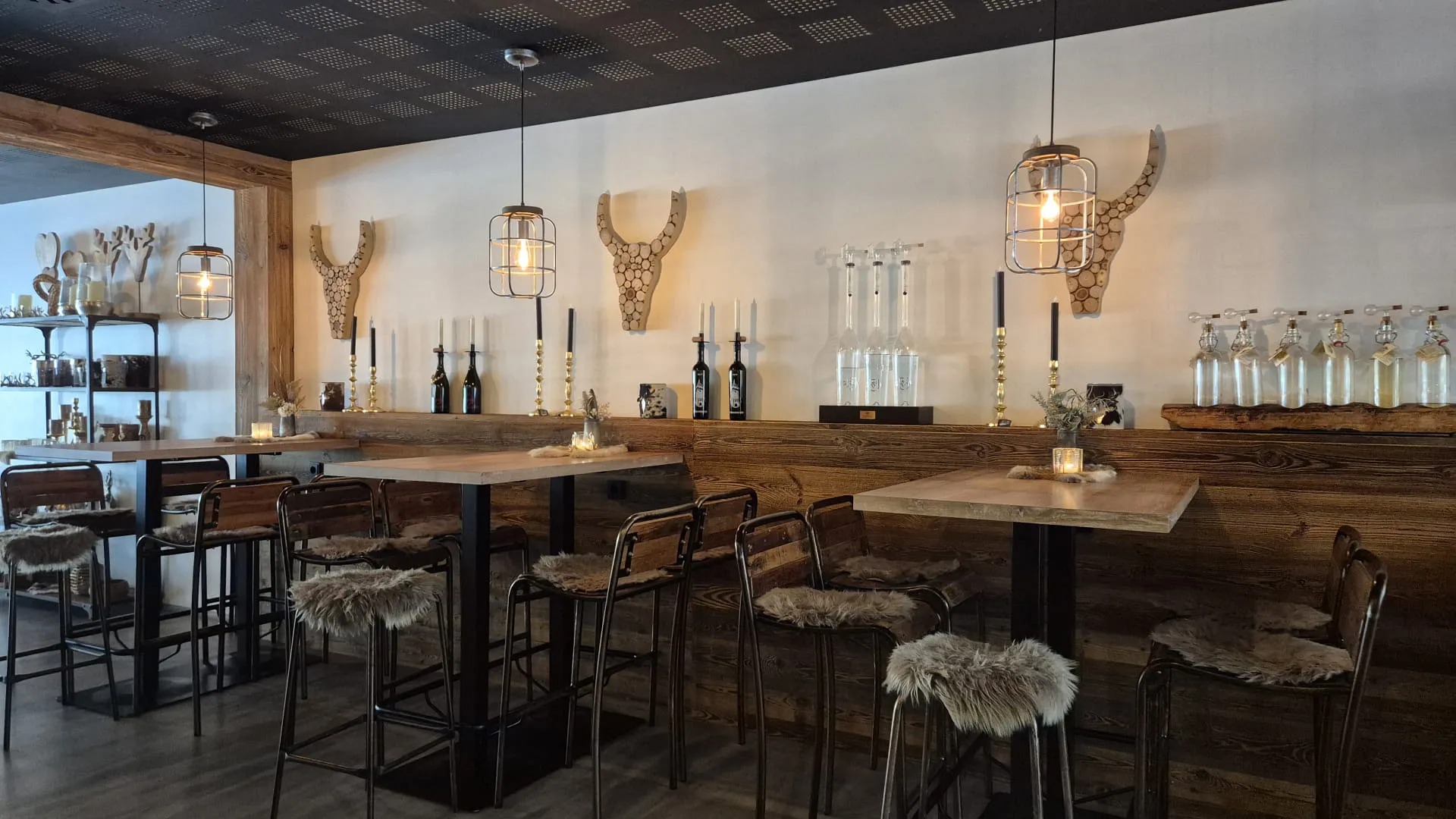 Moderne Bar mit Holzmöbeln, kreativen Leuchten und dekorativen Elementen.